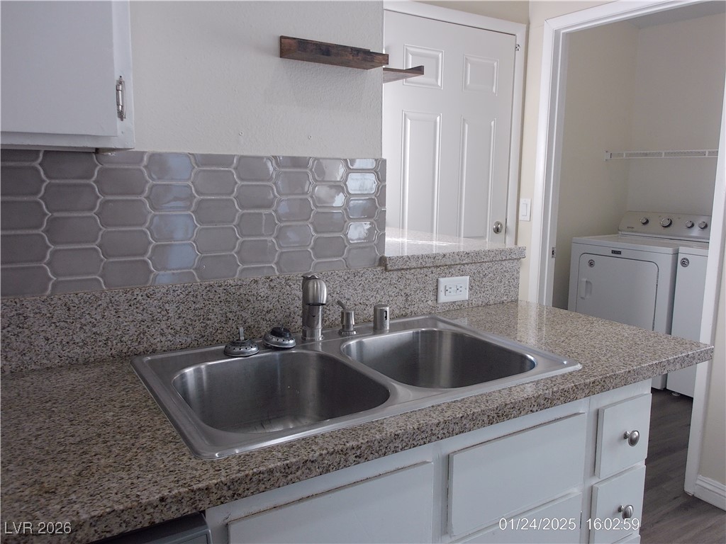 7313 Saybrook Point Drive Las Vegas, NV 89128 - Photo 9 of 31 Kitchen with white cabinets, washing machine and clothes dryer, open shelves, and tasteful backsplash