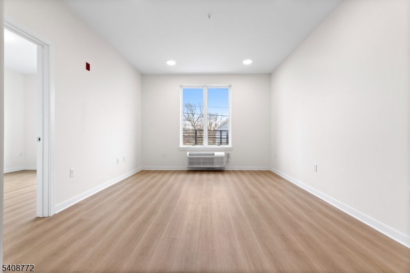 321 East 3rd Street, Unit 415 Plainfield, NJ 07060 - Photo 13 of 42 a view of an empty room with wooden floor and a window