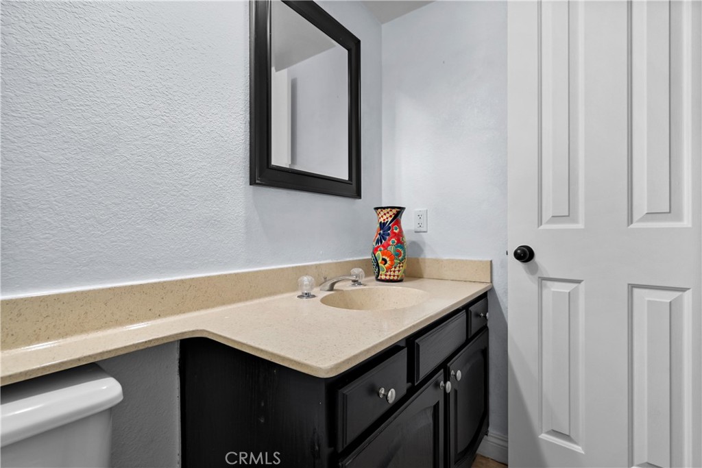 9321 Loquat Drive Riverside, CA 92508 - Photo 17 of 39 a bathroom with a sink vanity and a toilet
