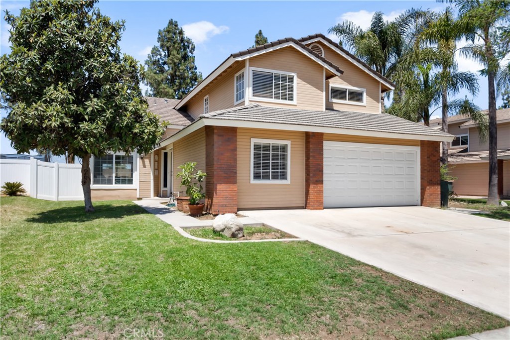 9321 Loquat Drive Riverside, CA 92508 - Photo 2 of 39 a front view of a house with a yard and garage