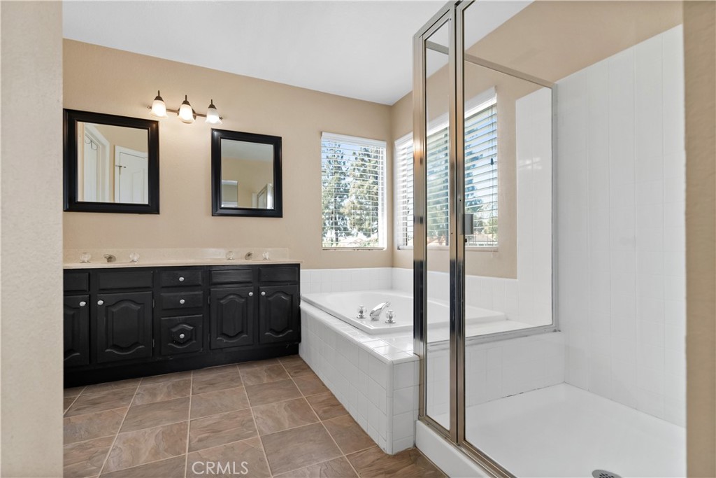9321 Loquat Drive Riverside, CA 92508 - Photo 25 of 39 a spacious bathroom with a tub sink shower and mirror