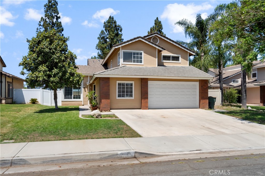 9321 Loquat Drive Riverside, CA 92508 - Photo 3 of 39 a front view of a house with a yard and garage