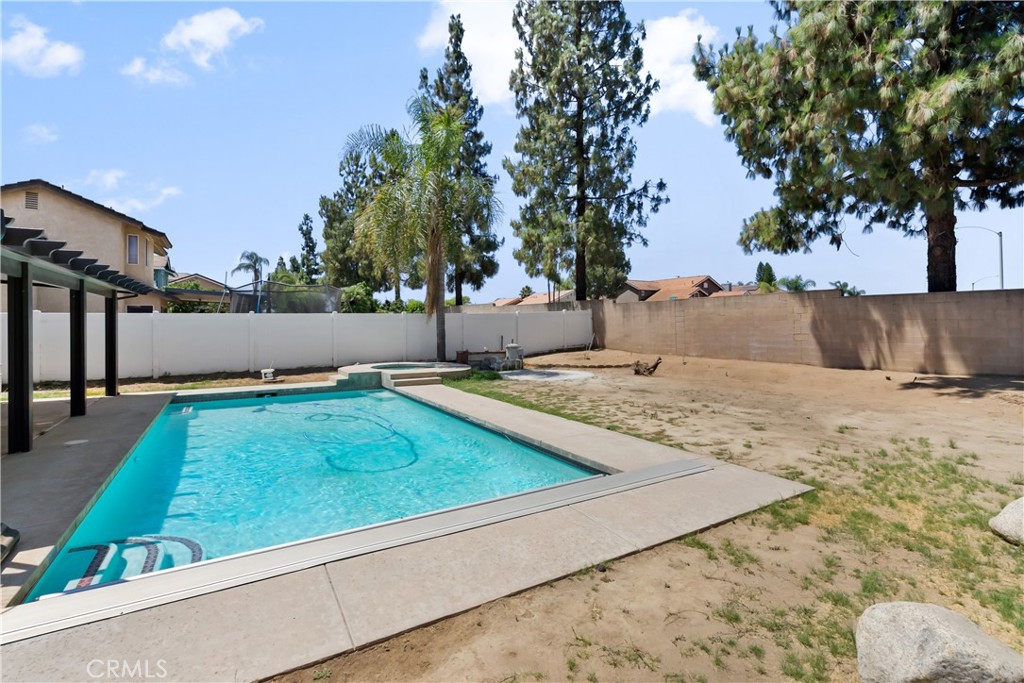 9321 Loquat Drive Riverside, CA 92508 - Photo 34 of 39 a view of swimming pool with a yard and trees