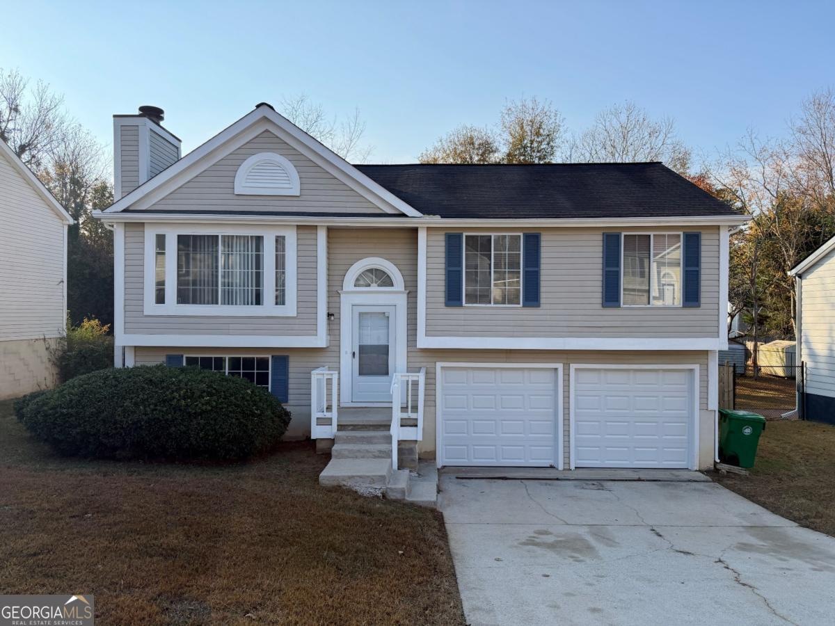 6091 Raintree Bend Lithonia, GA 30058 - Photo 1 of 14 a front view of a house with a yard and garage