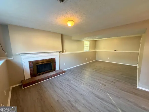 an empty room with wooden floor and fireplace