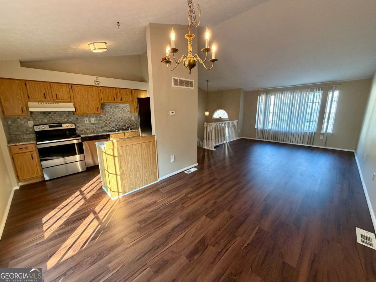 6091 Raintree Bend Lithonia, GA 30058 - Photo 5 of 14 a view of a kitchen with a sink wooden floor and cabinets