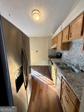 a kitchen with stainless steel appliances granite countertop a stove a sink and a refrigerator