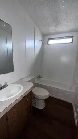 a bathroom with a granite countertop toilet a sink and a mirror