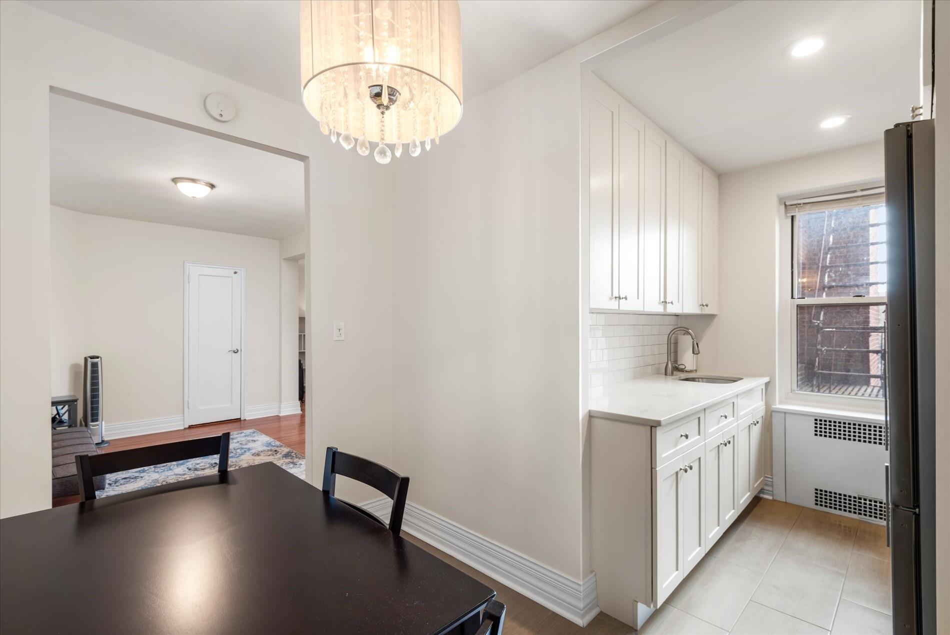 34-41 85th Street, Unit 4H Queens, NY 11372 - Photo 8 of 23 Dining room with recessed lighting, radiator, an inviting chandelier, light tile patterned flooring, and baseboards