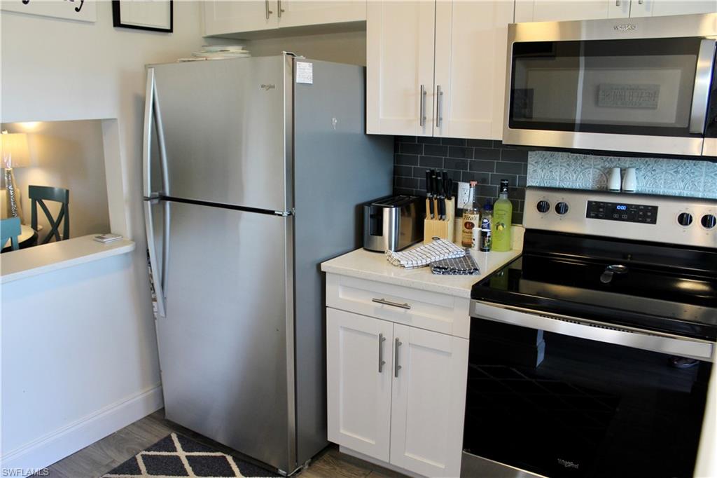 400 Forest Lakes Boulevard, Unit 309 Naples, FL 34105 - Photo 4 of 12 a kitchen with a refrigerator and a stove
