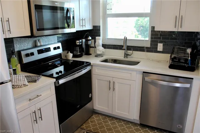 a kitchen with stainless steel appliances a sink stove and cabinets