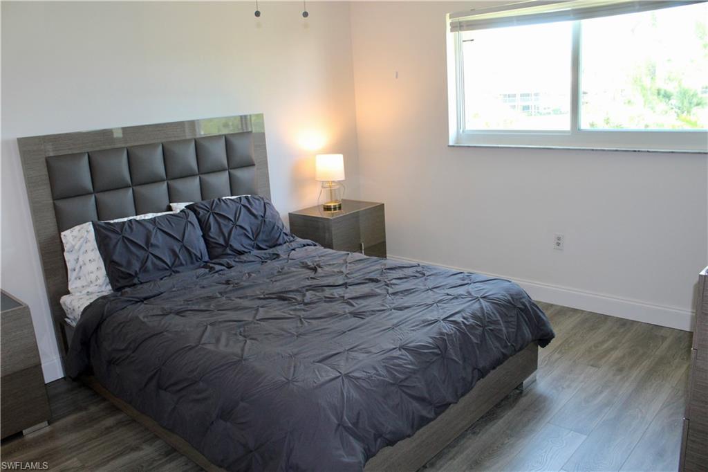 400 Forest Lakes Boulevard, Unit 309 Naples, FL 34105 - Photo 7 of 12 a bed sitting in a bedroom next to a window