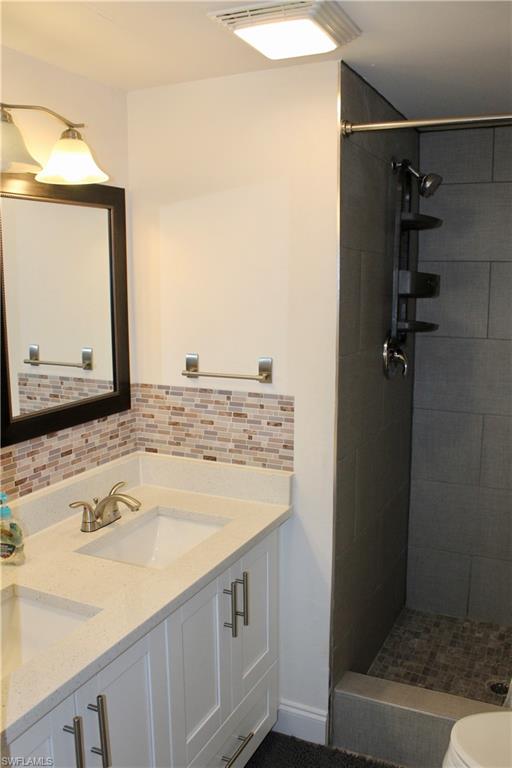 400 Forest Lakes Boulevard, Unit 309 Naples, FL 34105 - Photo 8 of 12 a bathroom with a granite countertop sink and a mirror