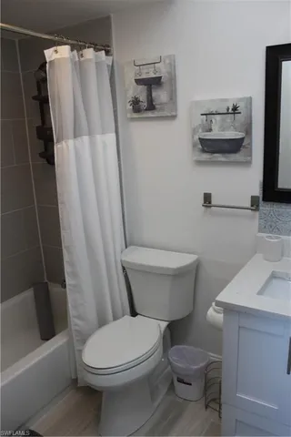 a white toilet sitting next to a bath tub