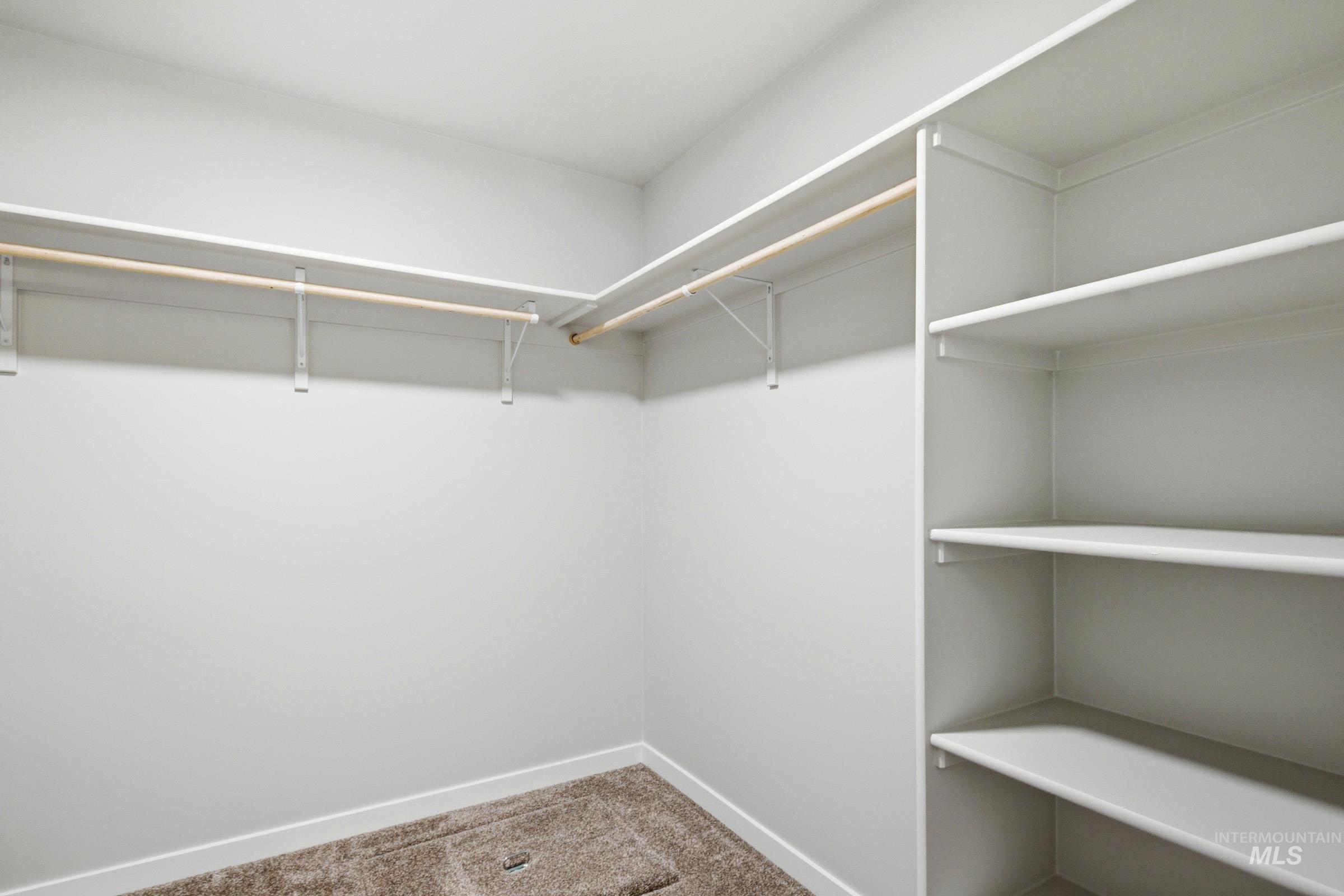 1184 West Jasper Street Meridian, ID 83642 - Photo 17 of 18 Walk-in closet featuring built-in shelving, two hanging rods, and neutral-toned carpeting