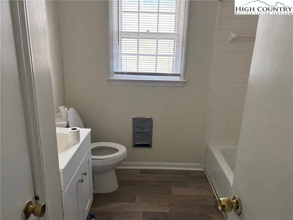 a white toilet sitting in a bathroom next to a window