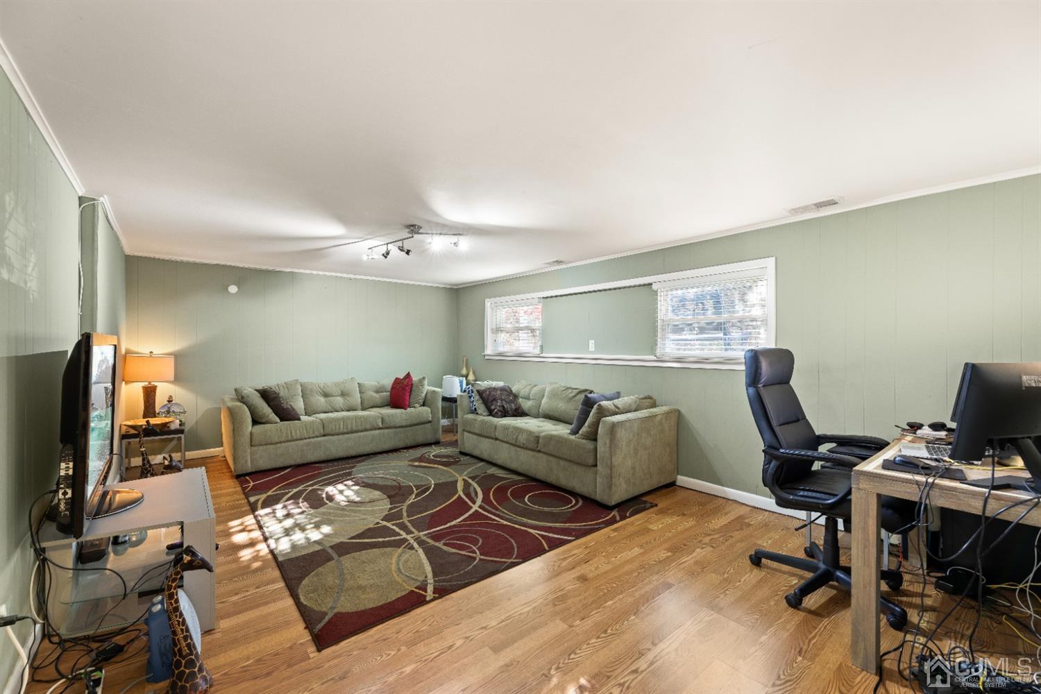 50 Wilk Road Edison, NJ 08837 - Photo 21 of 27 a living room with furniture a wooden floor and a flat screen tv