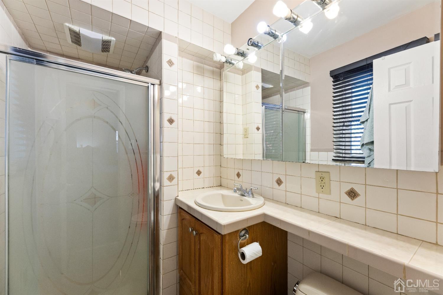 50 Wilk Road Edison, NJ 08837 - Photo 25 of 27 a bathroom with a sink and a mirror
