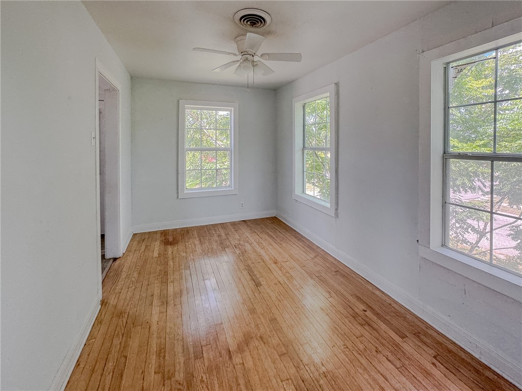 341 Sunset Avenue, Unit B Corpus Christi, TX 78404 - Photo 4 of 8 a view of an empty room with wooden floor and a window