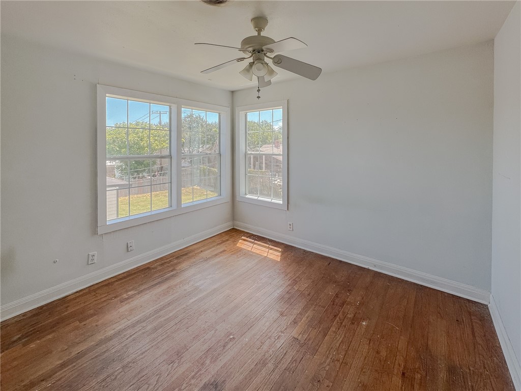 341 Sunset Avenue, Unit B Corpus Christi, TX 78404 - Photo 6 of 8 a view of an empty room with a window and wooden floor