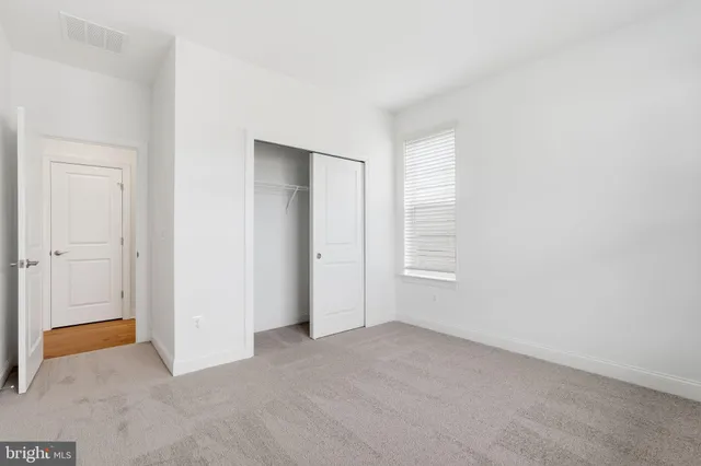 an empty room with windows and closet
