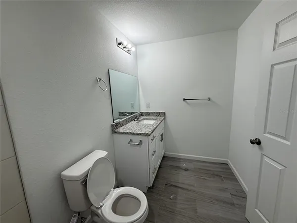 a bathroom with a granite countertop toilet and a sink