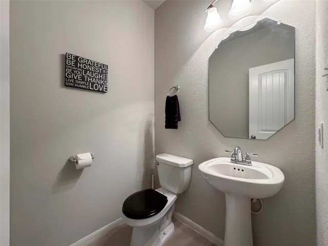 a bathroom with a sink a toilet and a mirror