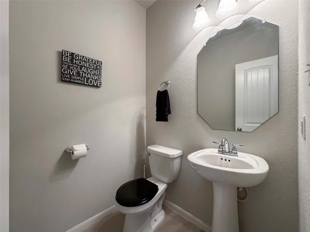 a bathroom with a sink a toilet and a mirror