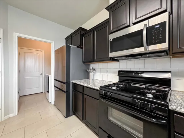 a kitchen with stainless steel appliances and cabinets