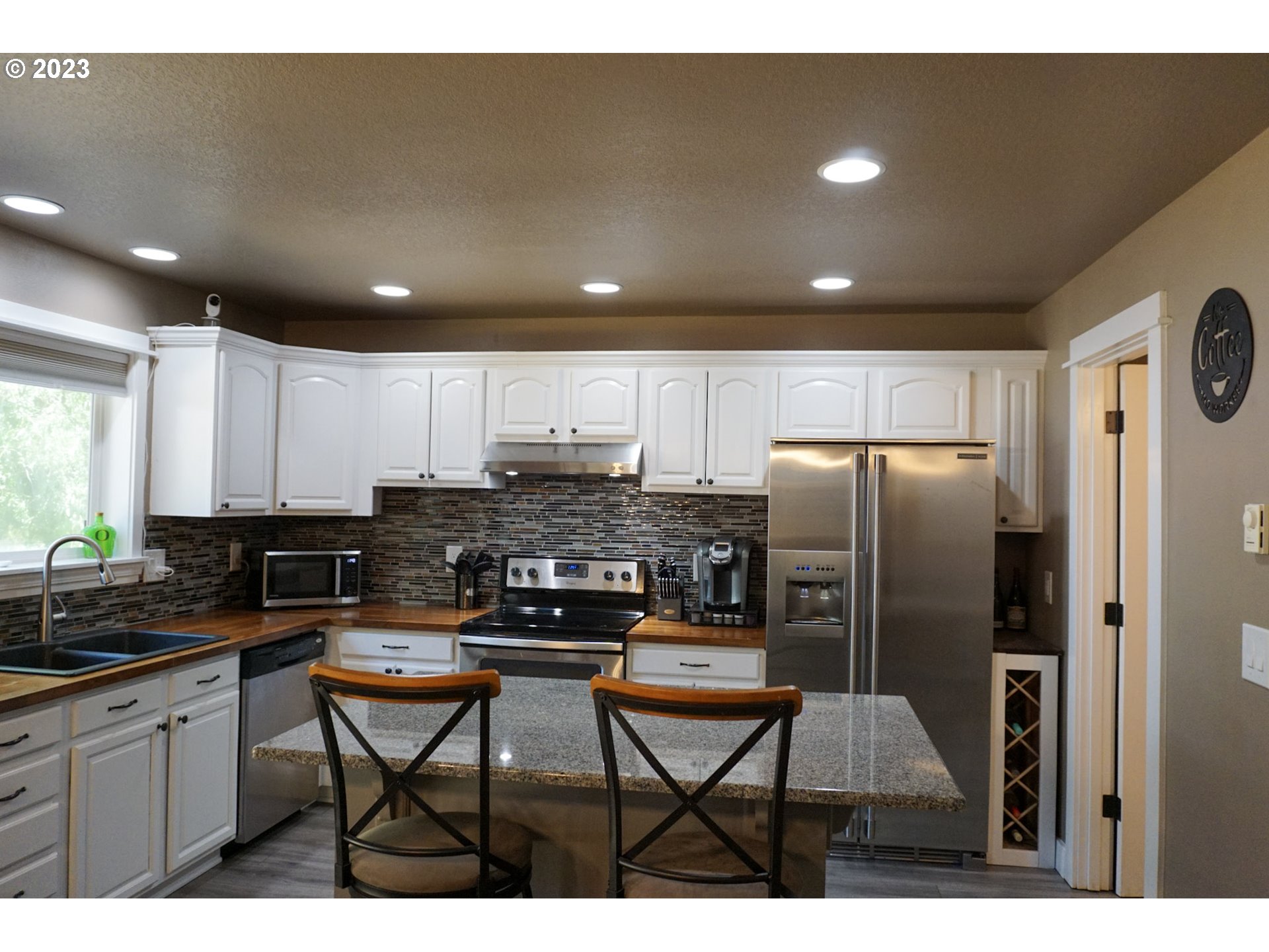 828 South 73rd Street Springfield, OR 97478 - Photo 4 of 23 a kitchen with stainless steel appliances a refrigerator sink stove dining table and chairs