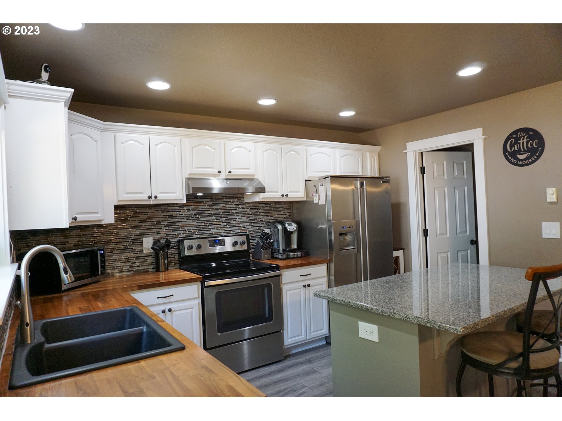 828 South 73rd Street Springfield, OR 97478 - Photo 5 of 23 a kitchen with stainless steel appliances granite countertop a stove a refrigerator a sink a dining table and chairs