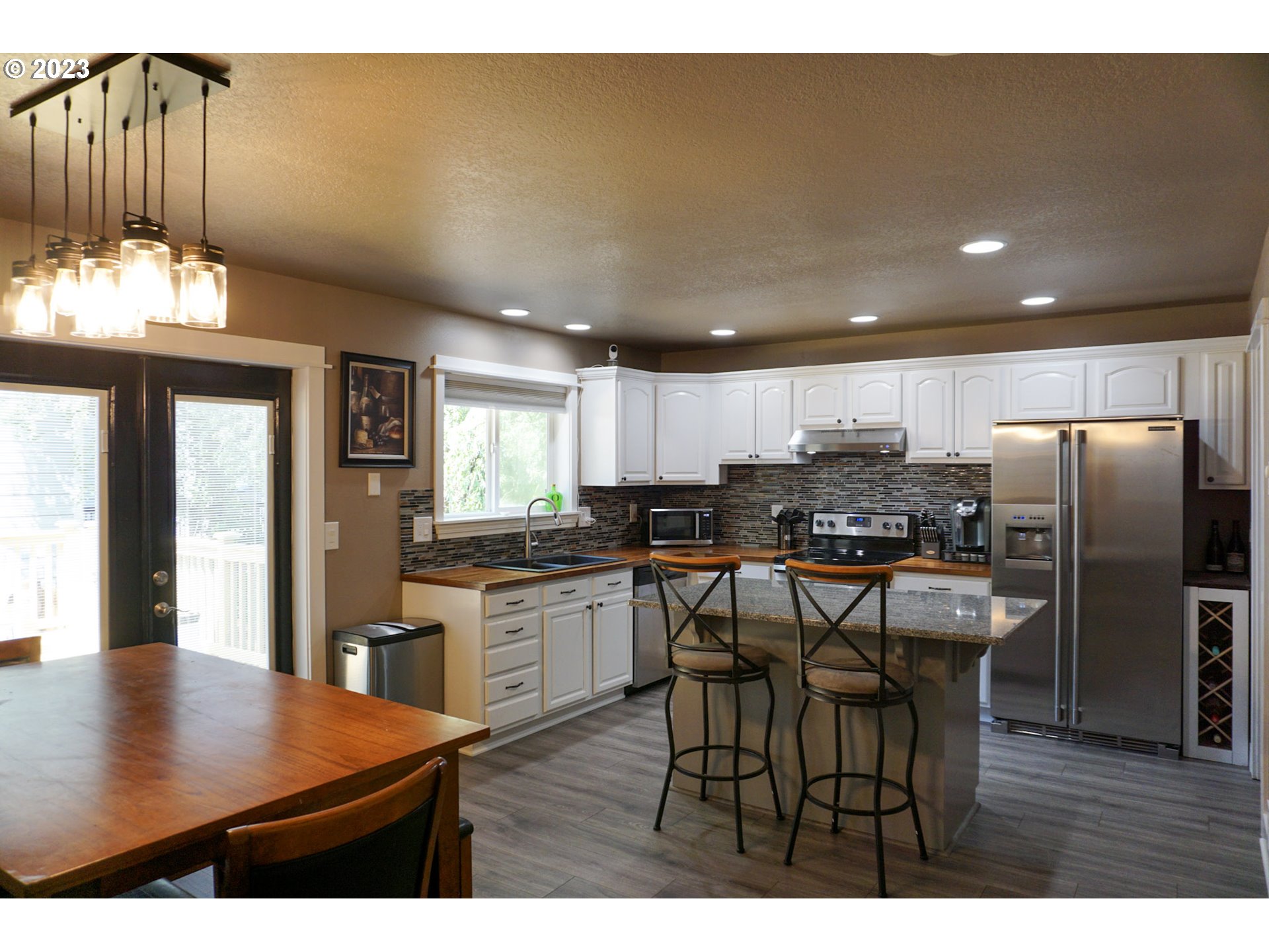 828 South 73rd Street Springfield, OR 97478 - Photo 6 of 23 a kitchen with stainless steel appliances kitchen island granite countertop a dining table chairs and granite counter tops