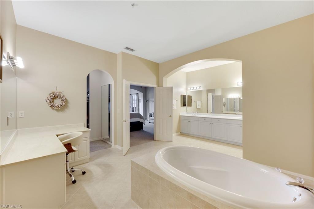 3530 Lansing Loop, Unit 202 Estero, FL 33928 - Photo 23 of 35 a bathroom with a tub sink and mirror