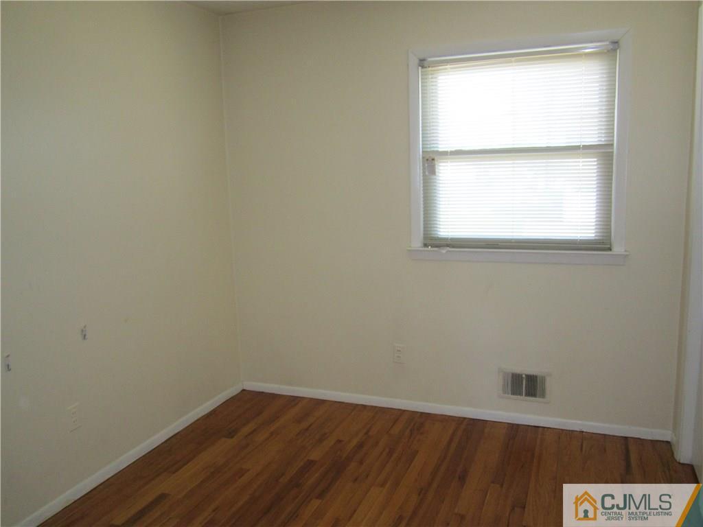 26 Outcalt Road Edison, NJ 08817 - Photo 13 of 23 a view of an empty room with wooden floor and a window