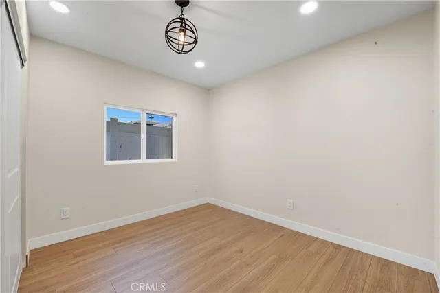 a view of a hallway with wooden floor and window