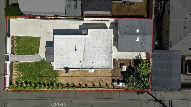 an aerial view of a house with a yard and large tree