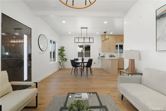 a living room with furniture a table and kitchen view