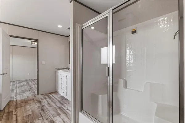 a bathroom with a shower and a glass door