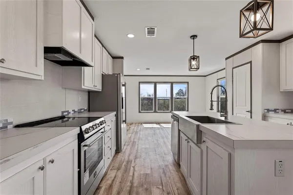 a kitchen with stainless steel appliances granite countertop a sink stove and cabinets