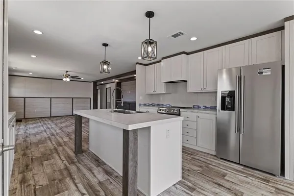a kitchen with kitchen island a sink stainless steel appliances and cabinets