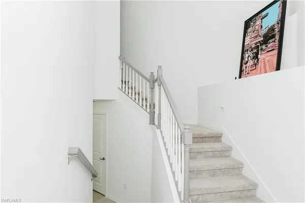 a view of staircase with wooden floor and white walls