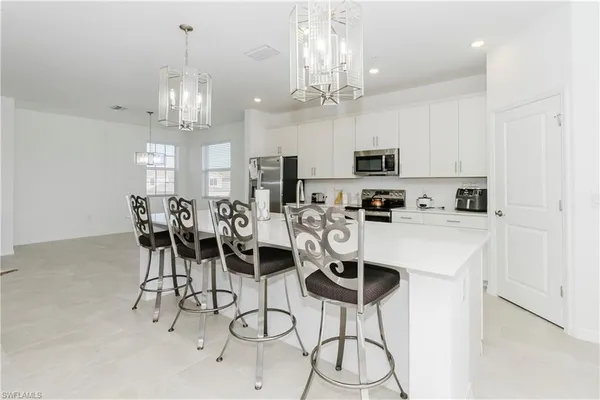 a kitchen with stainless steel appliances a table chairs and cabinets