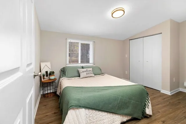 a bedroom with a bed and wooden floor