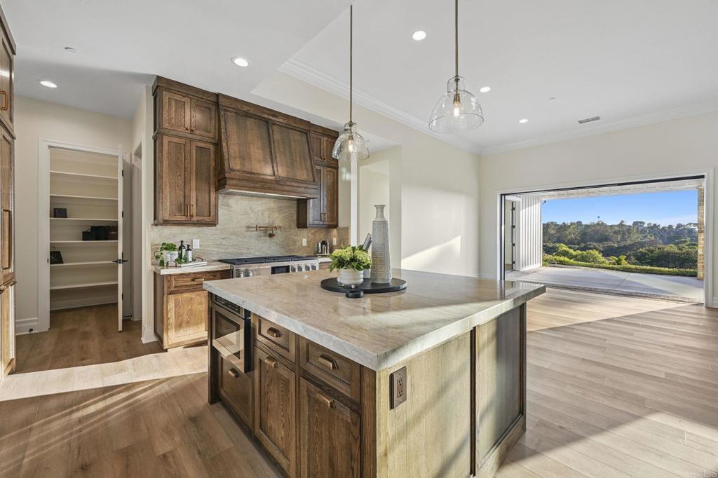 662 Lower Springs Road Fallbrook, CA 92028 - Photo 15 of 72 a kitchen that has a lot of cabinets a sink and wooden floor