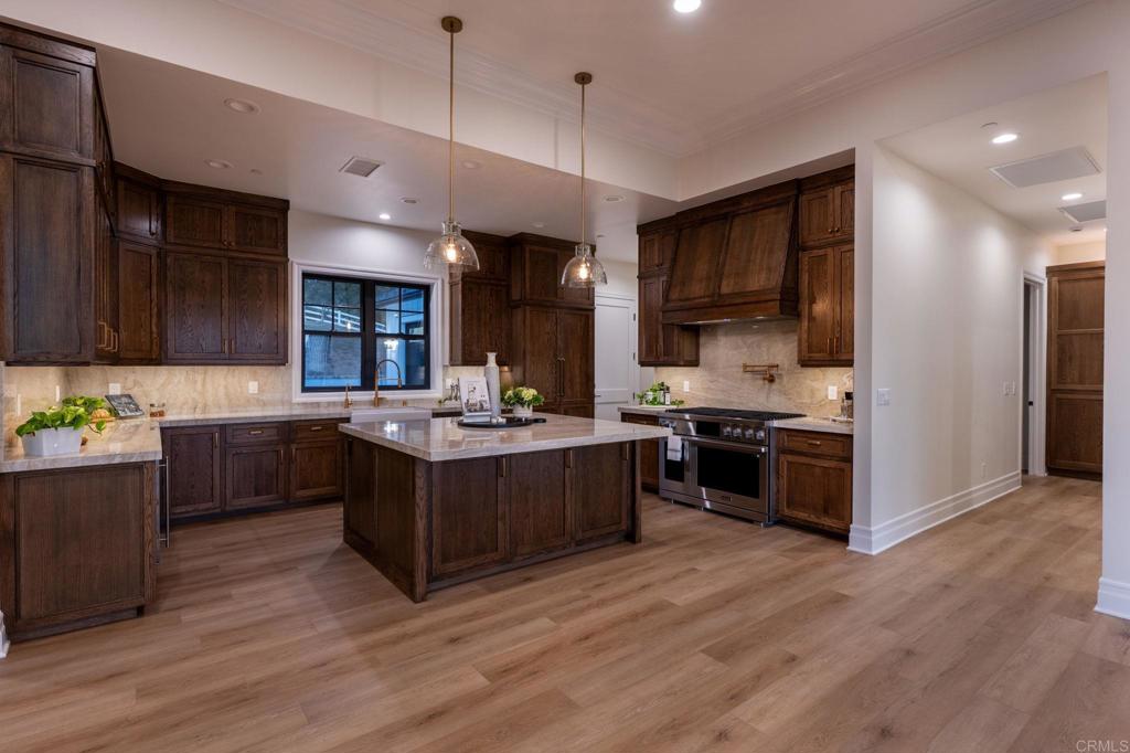 662 Lower Springs Road Fallbrook, CA 92028 - Photo 67 of 72 a large kitchen with stainless steel appliances granite countertop a large stove a sink dishwasher and a refrigerator with wooden floor