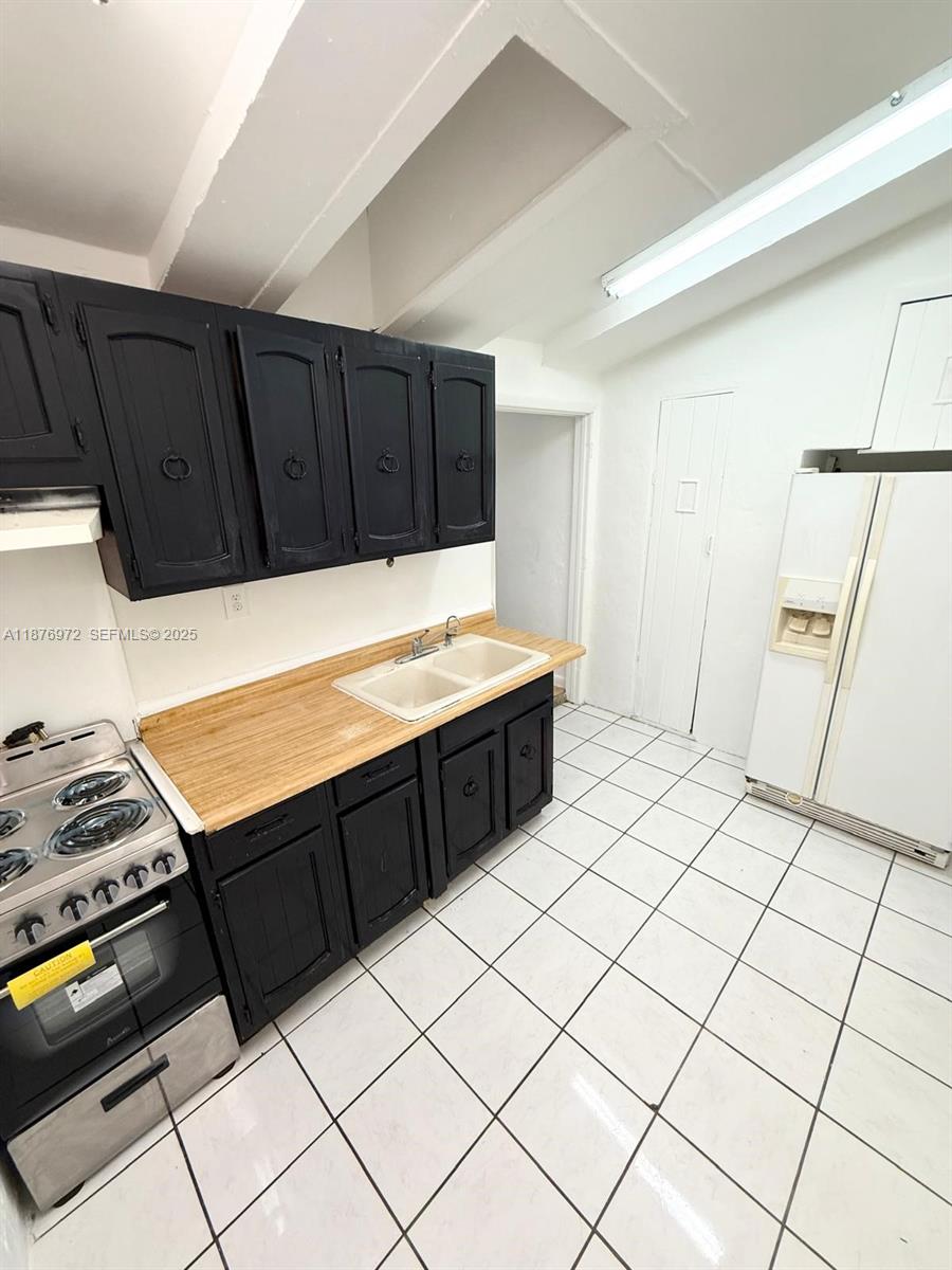 1340 Peri Street, Unit D Opa-Locka, FL 33054 - Photo 2 of 6 a room with a bed and a stove top oven