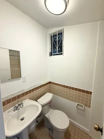 a bathroom with a sink mirror and toilet