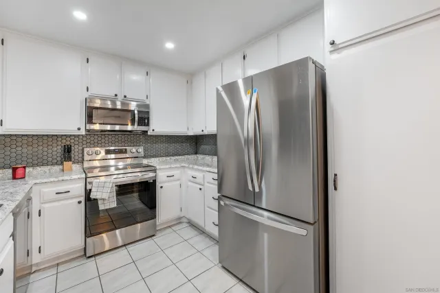 a kitchen with stainless steel appliances granite countertop a refrigerator sink and stove