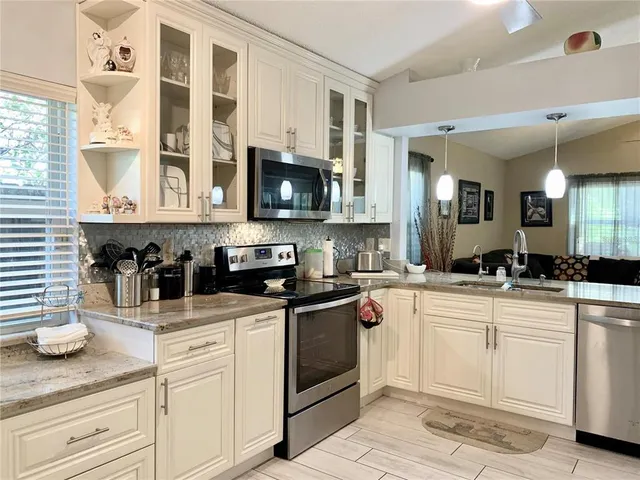 a kitchen with stainless steel appliances granite countertop a sink and cabinets