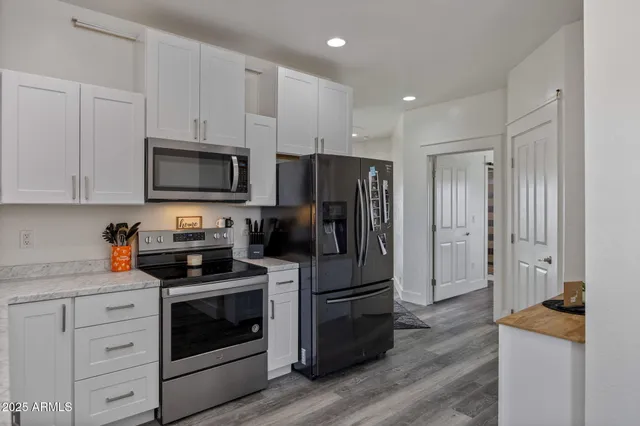 a spacious bedroom with a bed a couch and a chandelier
